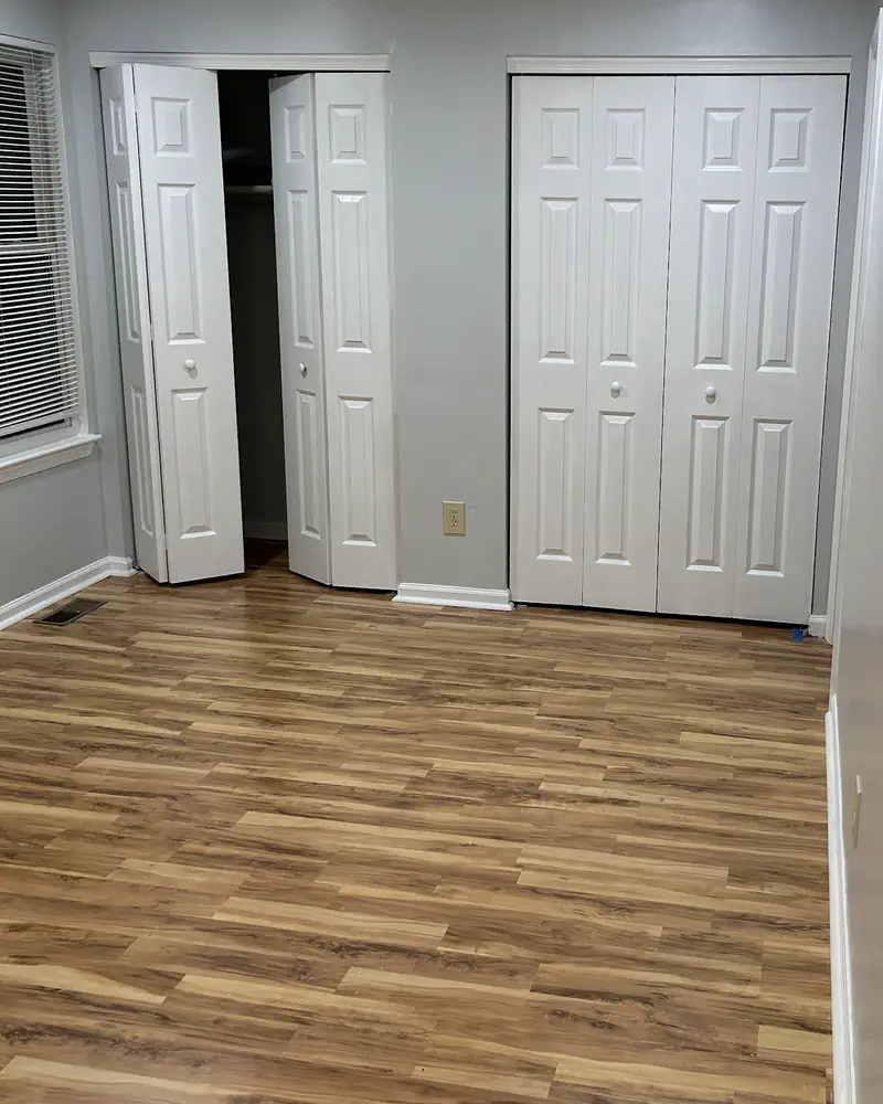 New white bifold closet doors over a wood-look laminate floor